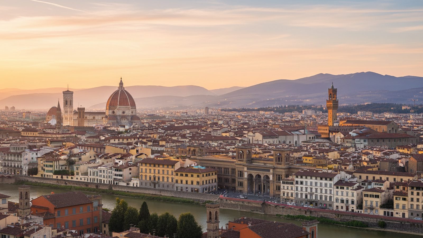 Firenze al tramonto vista dall’alto: la cupola del Duomo, il campanile e la torre di Palazzo Vecchio sopra i tetti, con le colline sullo sfondo